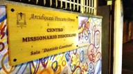 La targa del Centro missionario, circondata dai murales, in via Bardet